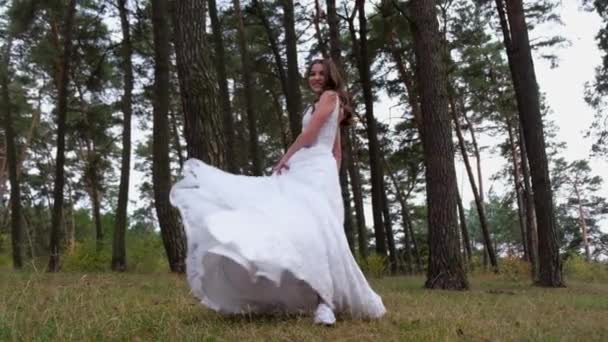 Die Braut im luxuriösen Kleid im Park, sie hat Spaß und verdreht das Kleid. — Stockvideo