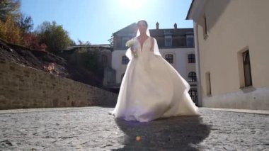 Gelinin güzel beyaz elbisesi, koşar ve güler.