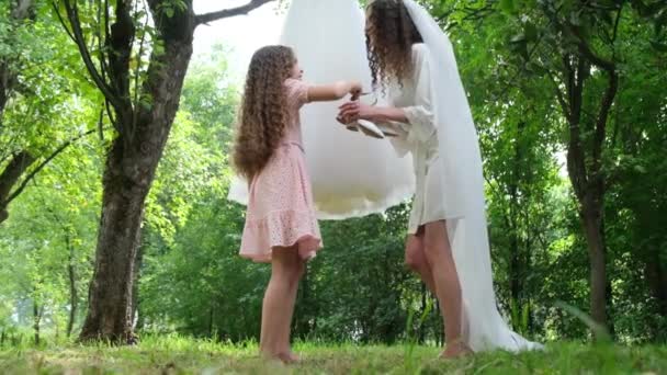 Küçük kız kardeş ayakkabıları kardeş gelinlere uzatıyor, duygusal bir an. Gelinin sabahı — Stok video