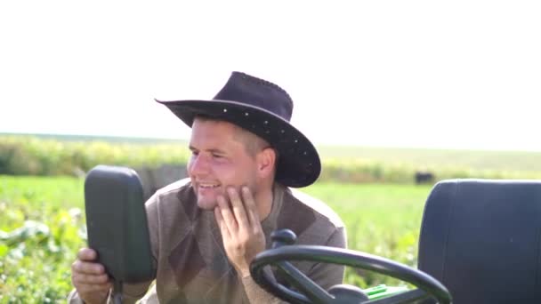 Feliz granjero cerca de su tractor verde. trabajador rural en su campo. — Vídeos de Stock