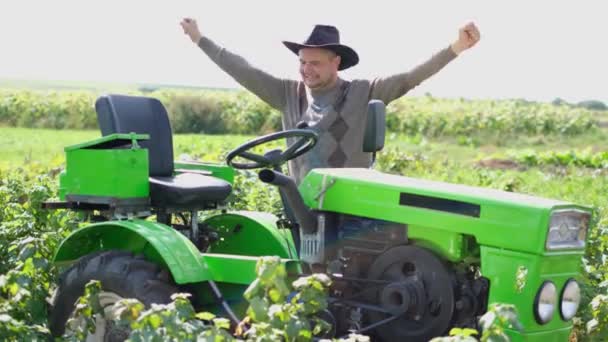 Een boer danst in de buurt van zijn tractor, een dorpswerker in het veld vroeg in de ochtend. — Stockvideo