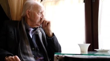 Yaşlı kel adamın başı ağrıyor. Umutsuzluk ve depresyon içinde.