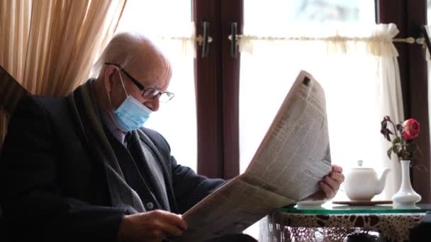 Retrato de un viejo abuelo de pelo gris con gafas en ropa elegante, lee el periódico — Vídeos de Stock