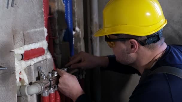 Un plomero masculino comprueba las tuberías de suministro de agua en la casa, manos de trabajador sistema de calefacción de fijación — Vídeo de stock