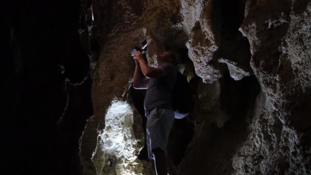 Ondergrondse onderzoeker, mannelijke archeoloog met een zaklamp in een grot. Speleologie, kerkers — Stockvideo