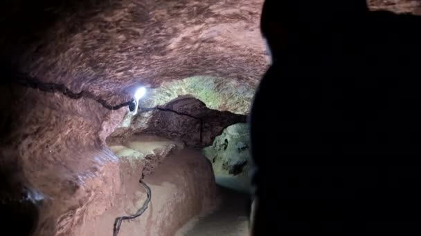 El arqueólogo rodea la mazmorra, ilumina el camino con una linterna. — Vídeo de stock