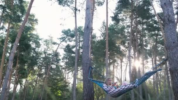 Mujer relajándose en el bosque en una hamaca. Ambiente de tranquilidad de relajación y felicidad. — Vídeos de Stock