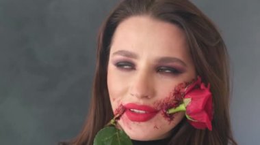 Cadılar Bayramı makyajlı esmer kız, yüzünde siyah bir elbise ve çiçek var.