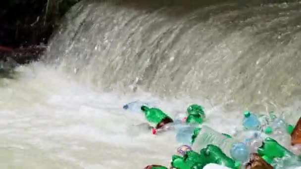 Plastik şişelerden dökülen çöp yığını. Kirli dağ nehri. — Stok video