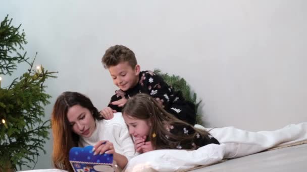 Jonge moeder met kinderen, ze heeft plezier en schrijft een brief aan de kerstman. — Stockvideo
