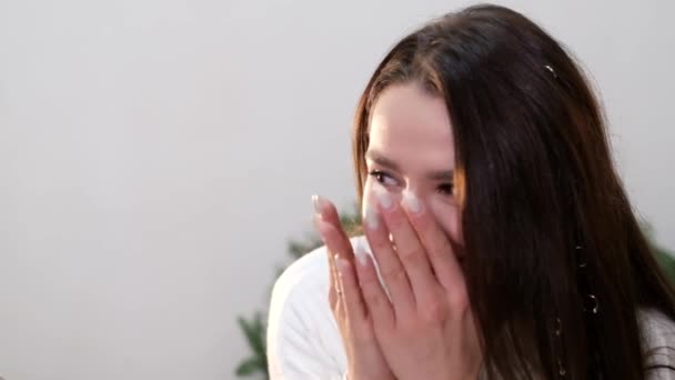 La fille brune ferme les yeux avec ses mains, elle rit joyeusement — Video