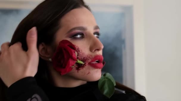 Vrouw in Halloween kostuum dragen heks make-up met bloem in de mond — Stockvideo