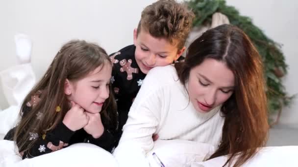 Schöne junge Mutter mit ihren Kindern, sie hat Spaß mit ihrem Sohn und ihrer Tochter — Stockvideo