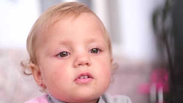 Portret van een blanke kleine baby, ze kijkt. Pensief kind — Stockvideo