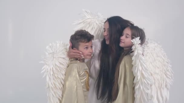 ครอบครัวที่มีปีกเทวทูตบนพื้นหลังสีขาว พวกเขาอยู่ในควัน — วีดีโอสต็อก
