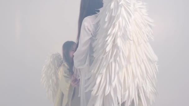 Joyeux famille avec des ailes d'ange blanc sur un fond blanc, ils sont heureux — Video