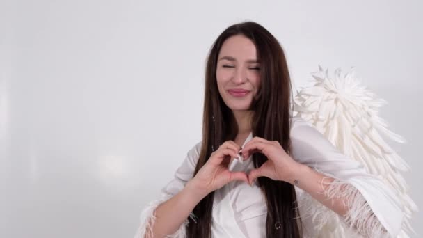 Brunette girl shows hands. The image of an angel with white wings — Stock Video