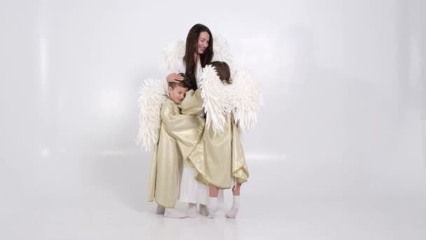 Joyeux famille avec des ailes d'ange blanc sur un fond blanc, ils sont heureux — Video