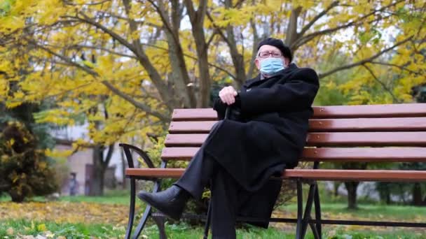Старый грустный дедушка сидит на скамейке в парке в Нью-Йорке. — стоковое видео