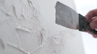 Genç yetenekli ressam büyük beyaz bir tuvale resim yapar, renkli, elle tutulur bir yağlı boya resim yapar.