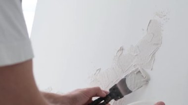 Stüdyoda tuvalin önünde çalışan genç bir sanatçı resim çiziyor, mutlu modern bir sanatçı.