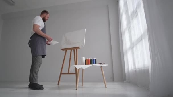 Man kunstenaar schetst een beeld met olieverf, kunstenaar tijdens het werken in het atelier — Stockvideo