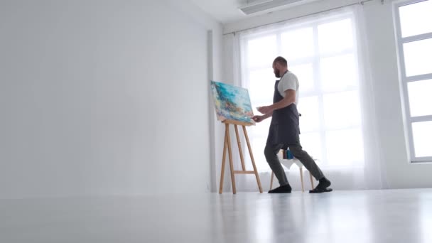 Мужчина художник рисует картину масляными красками, художник во время работы в студии — стоковое видео