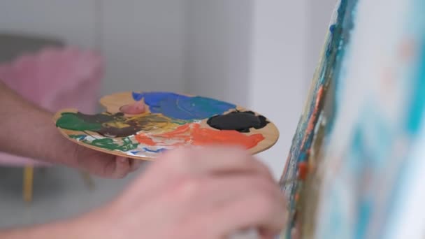 Nahaufnahme einer Hand des Künstlers, die einen Pinsel hält und ein Bild mit mehrfarbiger Farbe zeichnet. — Stockvideo