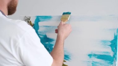 Stüdyoda, yan bakış açısında soyut resim üzerinde çalışan yetenekli bir sanatçı..