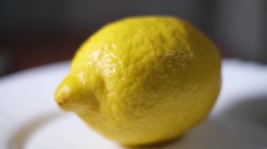 Olgunlaşmış sarı bir limonun makro videosu daire şeklinde dönüyor..