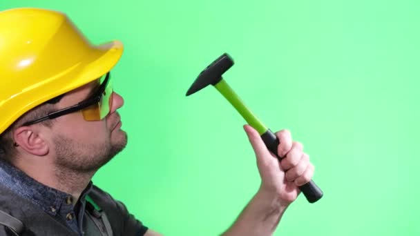 Male master beats with a hammer on the Chroma Key screen. tools isolated on green screen. — Stock Video