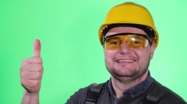 Stüdyoda bir erkek müteahhit portresi. Sarı bir kask takıyor. 