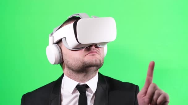 Business worker uses virtual reality glasses on the background of a chromakey — Wideo stockowe