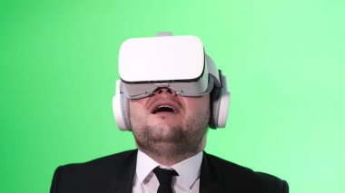 Şaşkın ofis çalışanı sanal gerçeklik gözlüğü kullanıyor. Yeşil kromakey arkaplanı