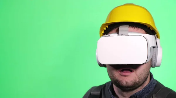 Young European worker uses virtual reality goggles on chromakey background — Foto de Stock