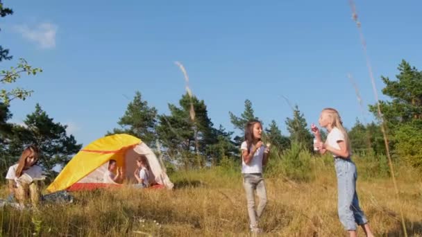 Літній табір з наметом у лісі, діти розважаються та грають у ігри . — стокове відео