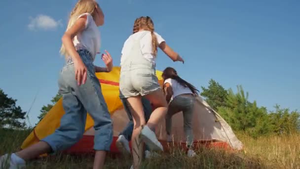 A group of children enters the tent, teenage girls rest in a school camp with a tent camp. — Vídeos de Stock