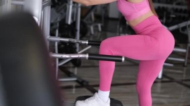 Avrupalı bir kadın güzel vücuduyla spor salonunda güreşiyor. Kas eğitimi sırasında profesyonel atlet 