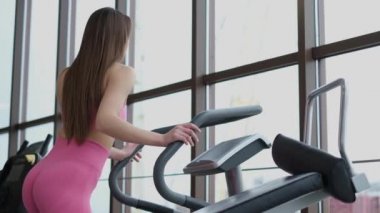 Güzel bir kızın kardiyo eğitimi. Spor salonunda profesyonel bir sporcu.. 