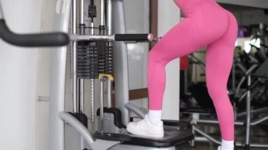 Spor salonunda bacak kası egzersizi yapan antrenör kız. Güzel aktif atlet. 