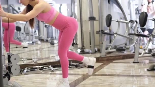 Menina atlética treina os músculos das nádegas, ela tem uma bela figura muscular. — Vídeo de Stock