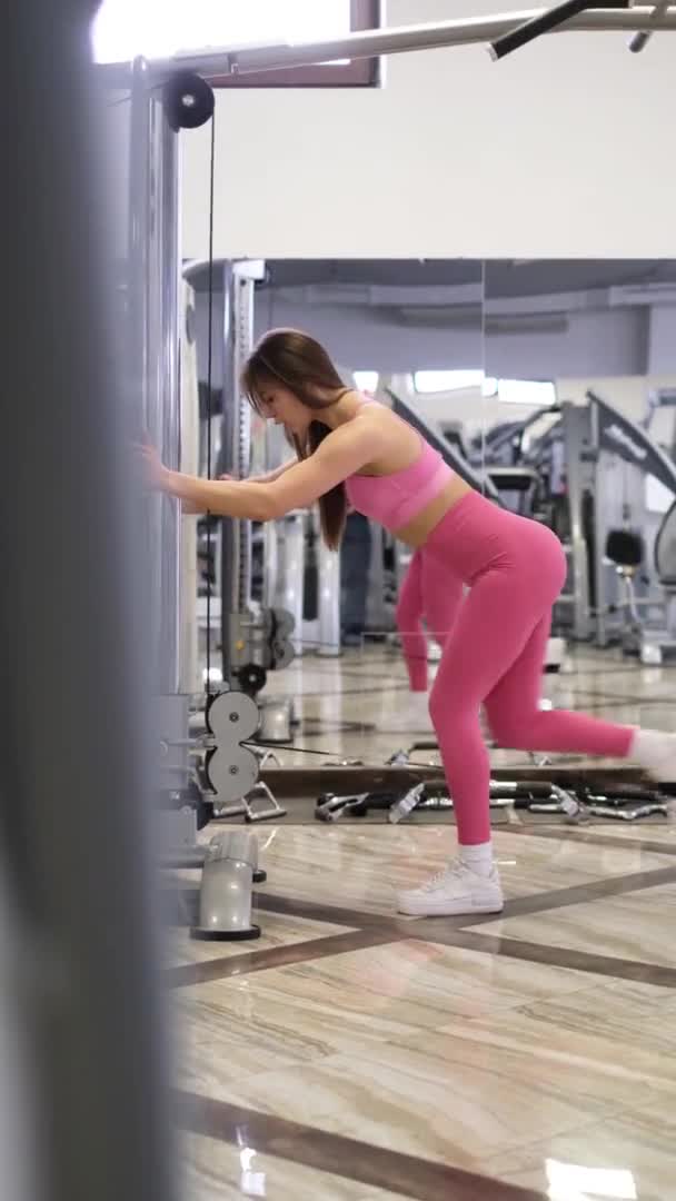 Europeisk kvinna brottas med sin vackra kropp i gymmet. professionell idrottare under muskelträning — Stockvideo
