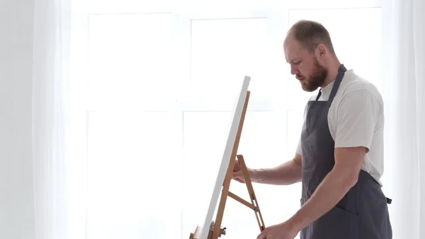 The young talented artist paints on a large white canvas, creates a colorful — Foto de Stock