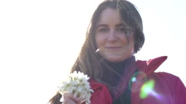 Güzel gülümseyen esmer kız elinde bir buket kardamlası tutuyor ilk bahar çiçekleri.