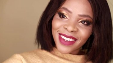 Genç bir Afrikalı Amerikalı kadın Selfie 'lere gülümsüyor. Bir kız sosyal ağlar için akıllı telefon kullanıyor.