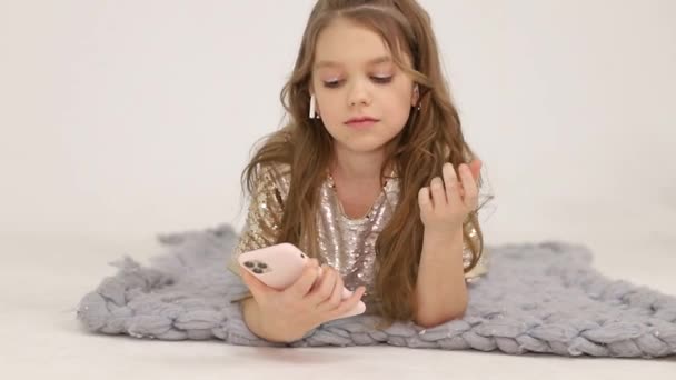 Little girl listens to music with wireless headphones. Happy child — Stockvideo