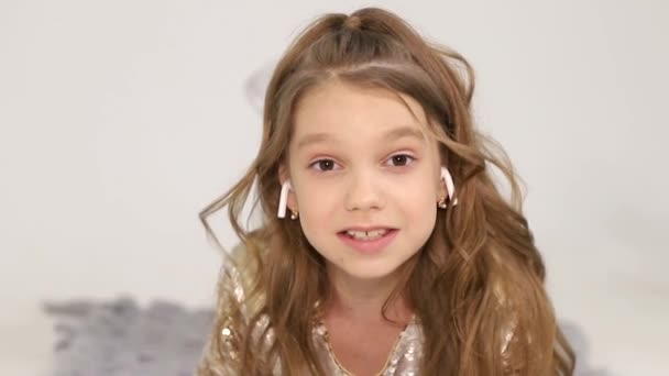 A kislány vezeték nélküli fejhallgatóval hallgat zenét. Boldog gyermek. — Stock videók