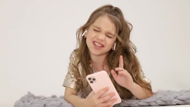 Little girl listens to music with wireless headphones. Happy child — Vídeo de Stock