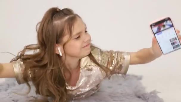 Little girl listens to music with wireless headphones. Happy child — Vídeos de Stock