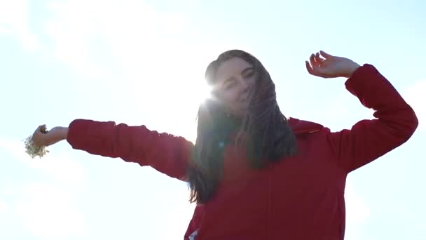 Morena chica en una chaqueta roja baila en el sol. — Vídeos de Stock